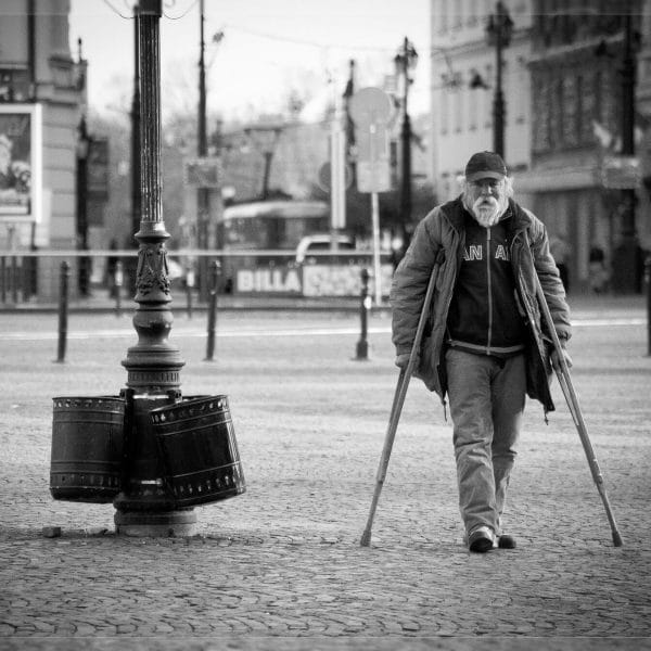 Old man walking on crutches