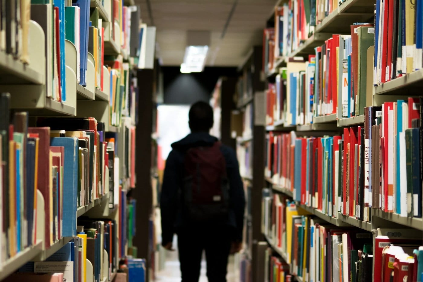 International student walking in a library.