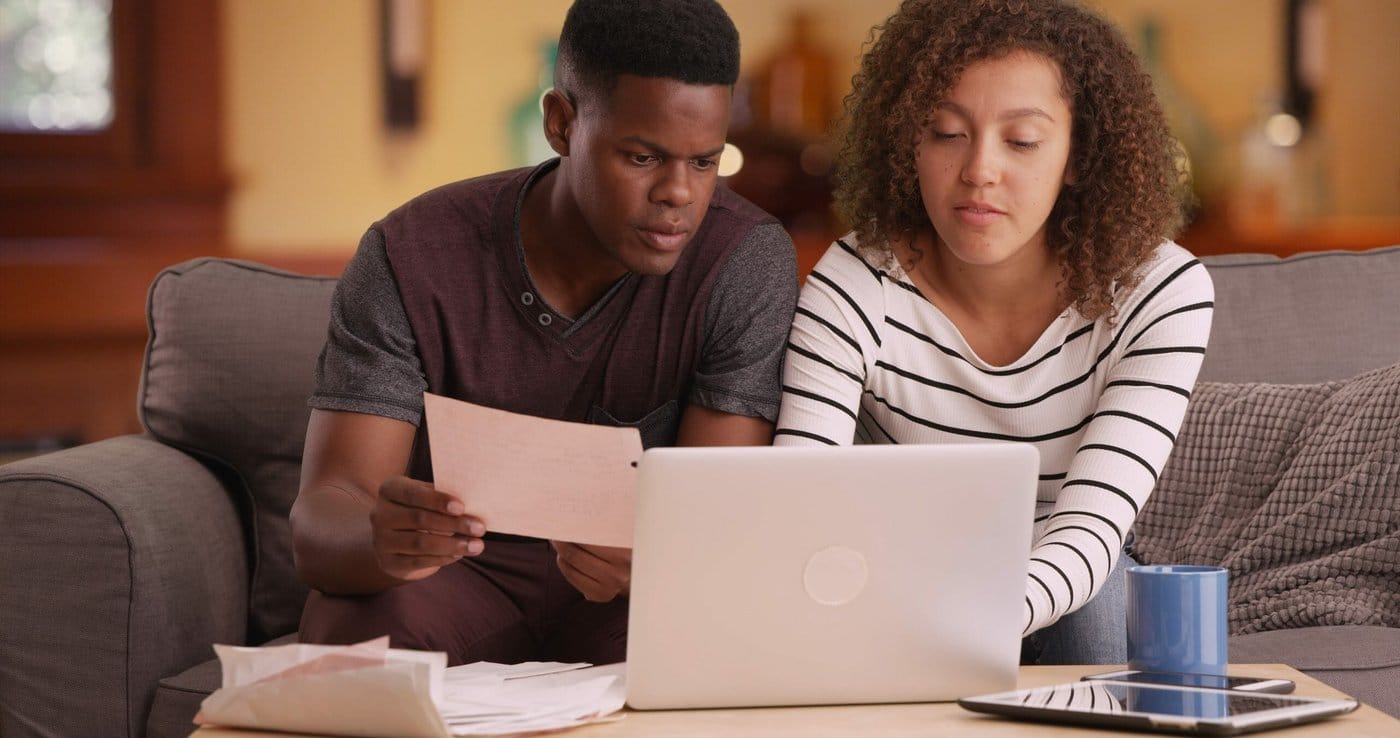African American couple pays their bills on their laptop A couple pay their bills.
