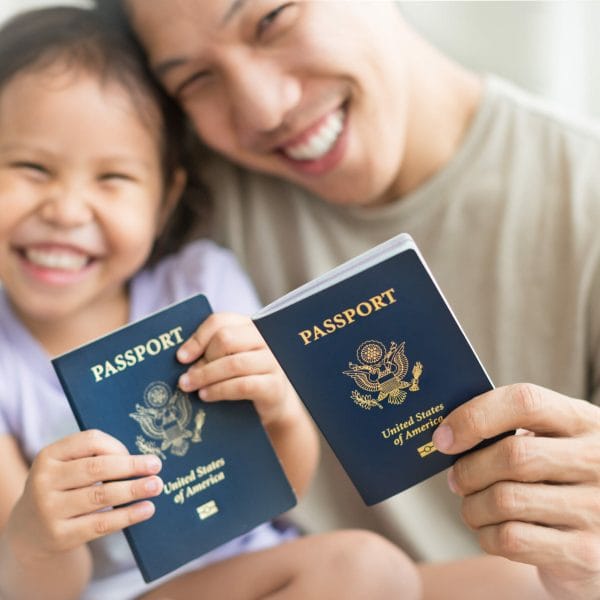 Asian dad and daughter holding amercian passports with pride. Immigration citizenship