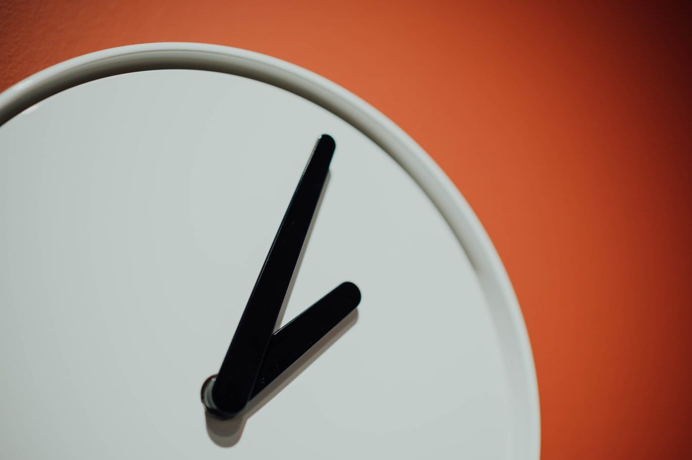 A clock against an orange background. 