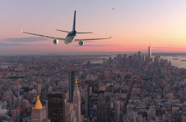 Passenger plane flying into New York at sunset.