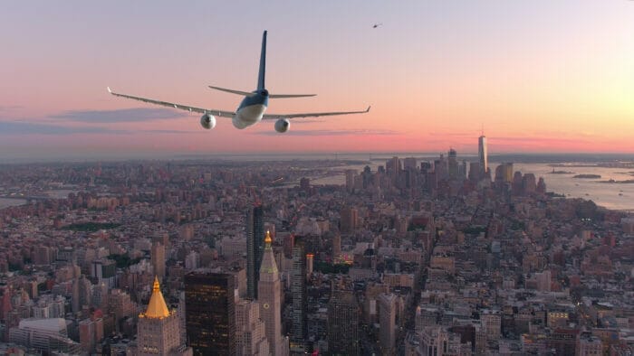 Passenger plane flying into New York at sunset.