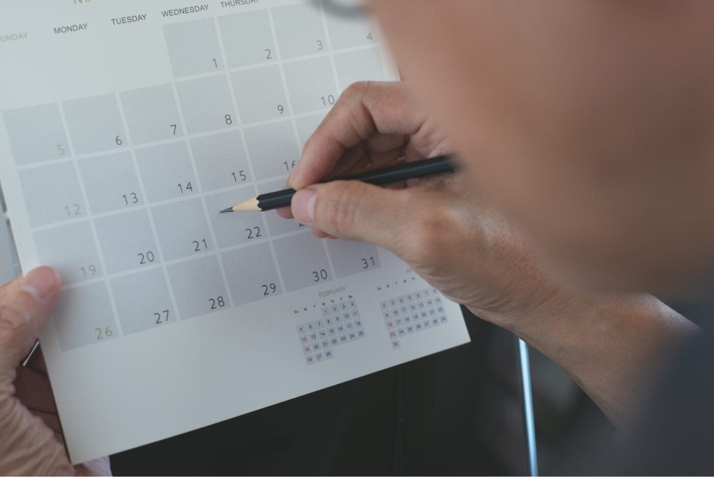 Business man planning his work schedule on calendar event planner, timetable in office